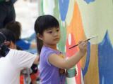 A little artist painting a mural at the new centre